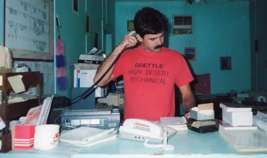 Goettl’s High Desert Mechanical staff member handling paperwork in early office workspace – Prescott Valley AZ