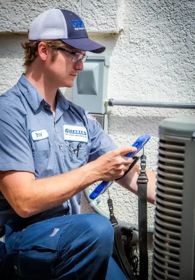 Goettl’s High Desert Mechanical technician using HVAC gauges while servicing outdoor unit – Prescott Valley AZ