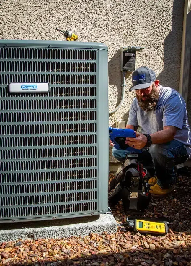 Goettl’s High Desert Mechanical technician inspecting wiring on outdoor condenser unit – Prescott Valley AZ