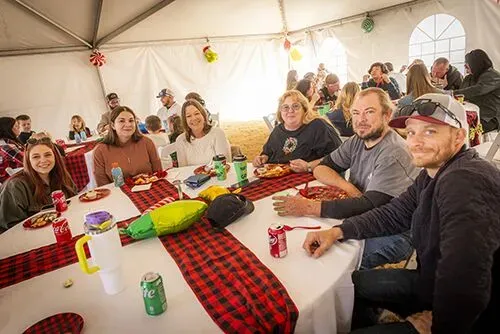 Families sitting at decorated tables inside event tent during holiday gathering – Goettl’s High Desert Mechanical Prescott Valley AZ