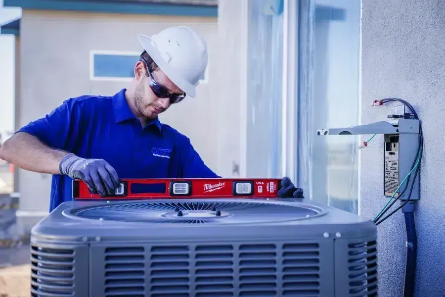 Technician leveling and inspecting outdoor HVAC condensing unit – Goettl’s High Desert Mechanical Prescott Valley AZ