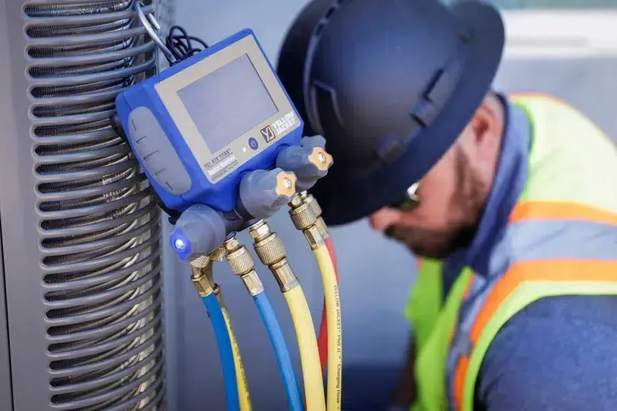 HVAC technician connecting digital manifold gauge set to outdoor unit – Goettl’s High Desert Mechanical Prescott Valley AZ