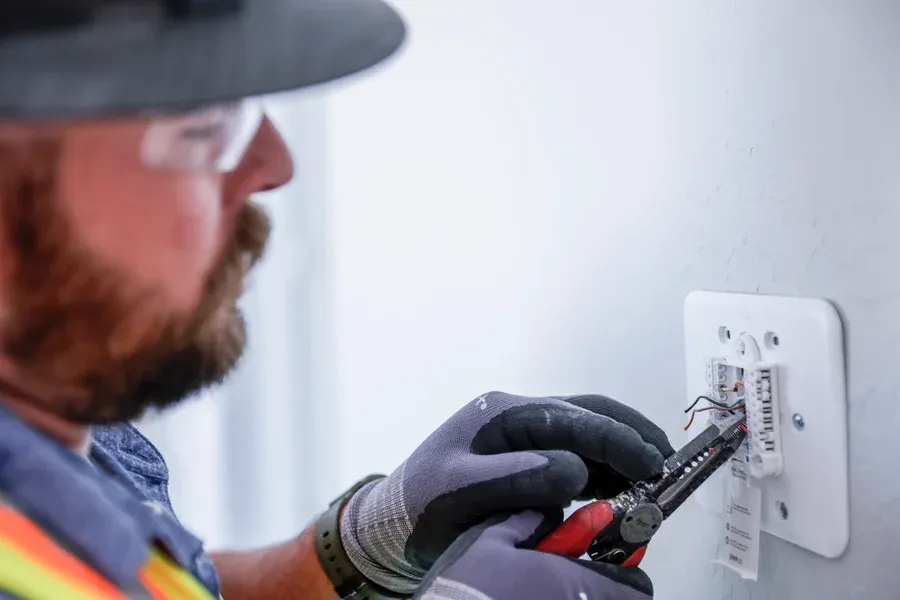 Technician tightening thermostat wiring during indoor HVAC service – Goettl’s High Desert Mechanical Prescott Valley AZ