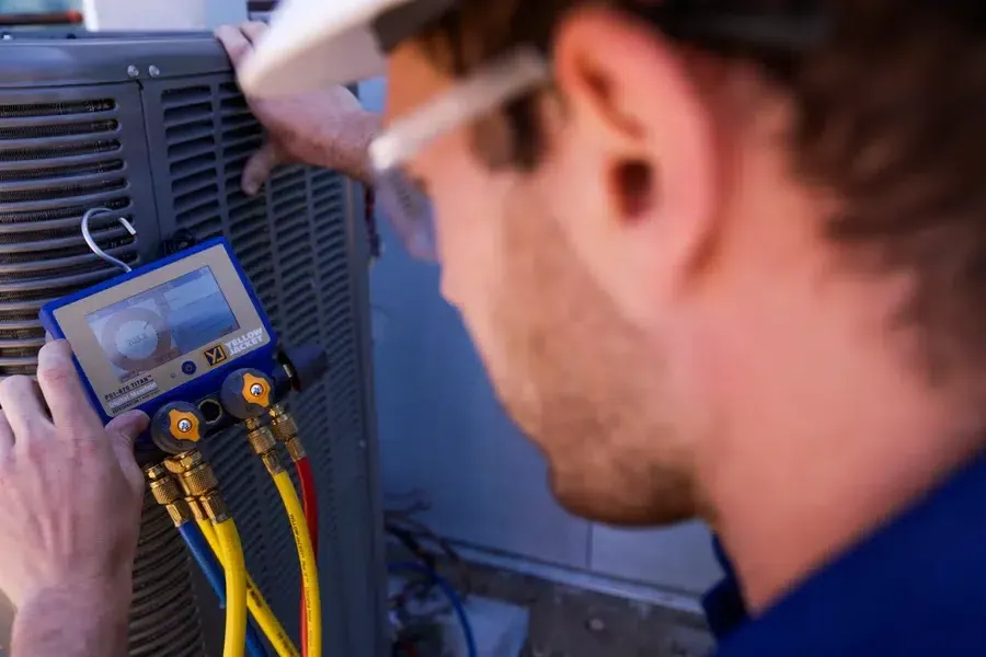 Technician inspecting cooling system components outdoors – Goettl’s High Desert Mechanical Prescott Valley AZ