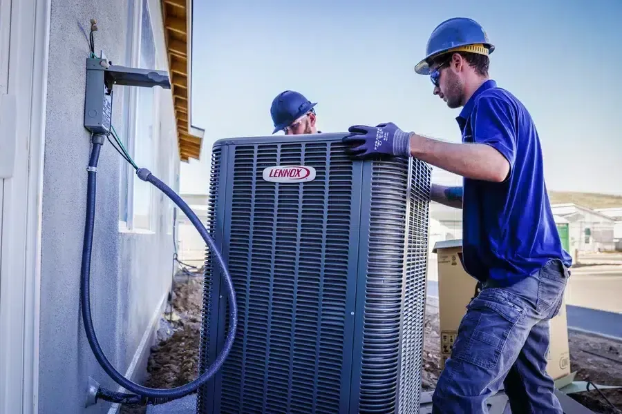 Technicians servicing outdoor HVAC condenser unit on jobsite – Goettl’s High Desert Mechanical Prescott Valley AZ