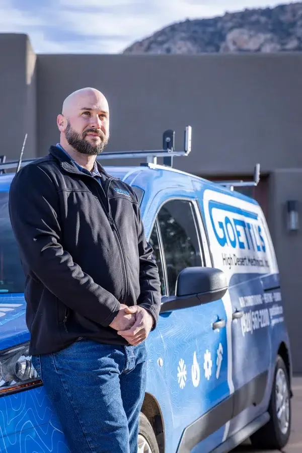 Goettl’s High Desert Mechanical technician standing near service van in desert neighborhood – Prescott Valley AZ