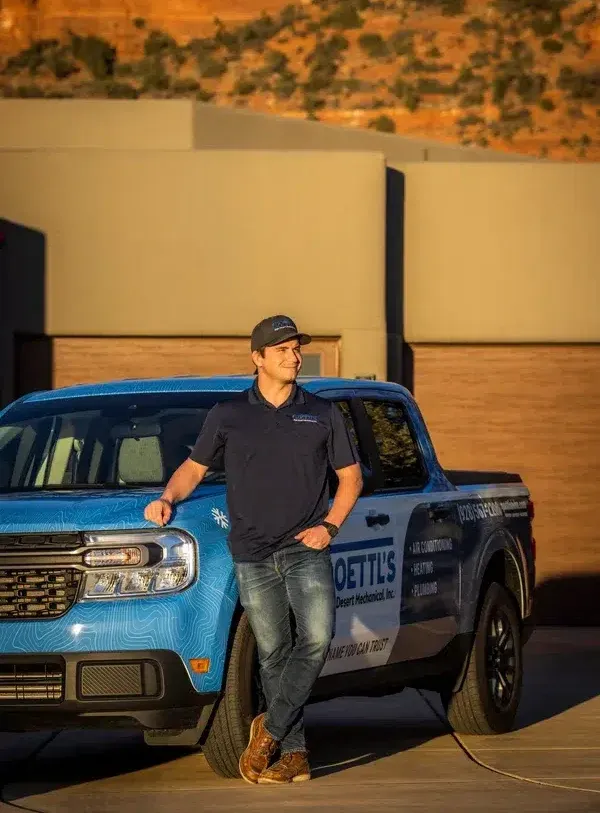 Goettl’s High Desert Mechanical technician posing beside service truck near desert home – Prescott Valley AZ