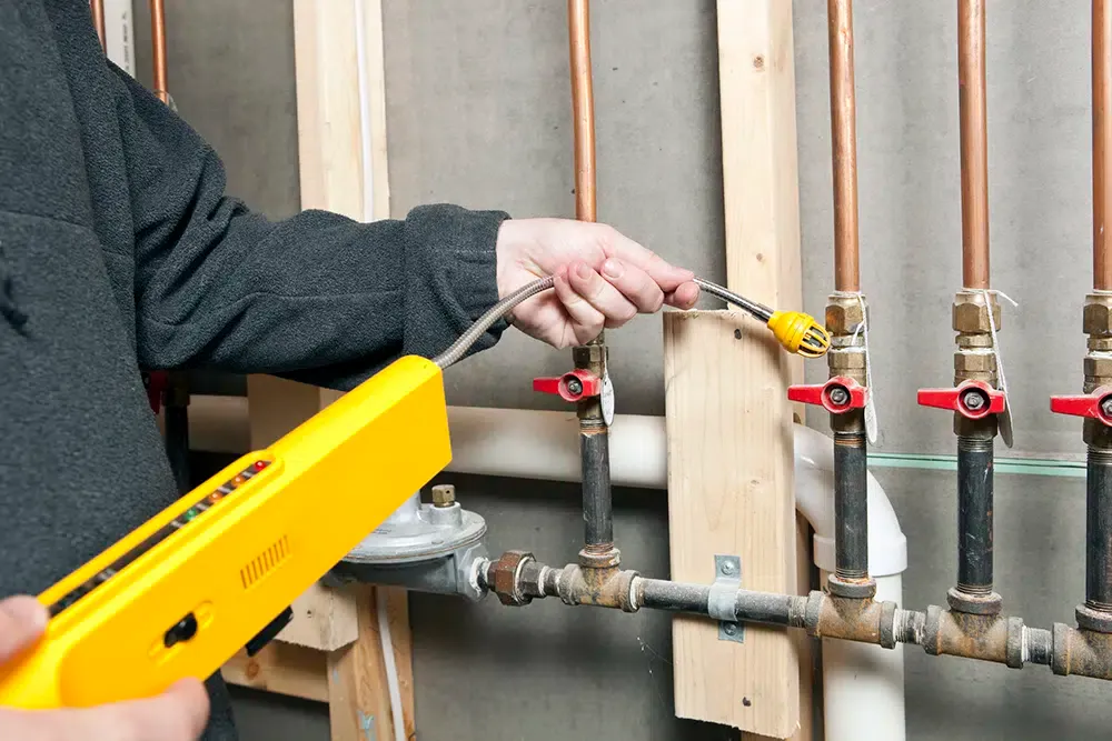 Tech using gas leak detector near a set of house gas lines – Prescott Valley AZ