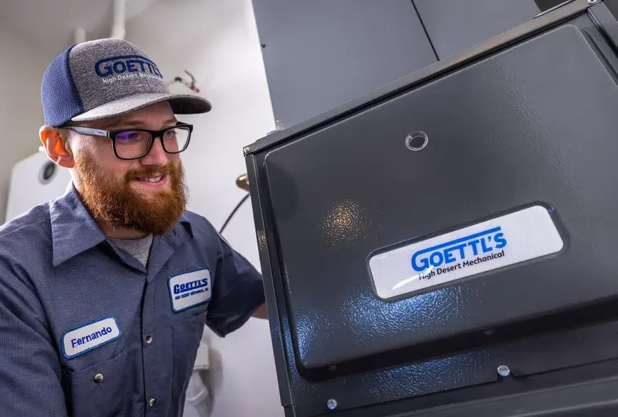 Goettl’s High Desert Mechanical technician standing next to outdoor condenser during installation – Prescott Valley AZ