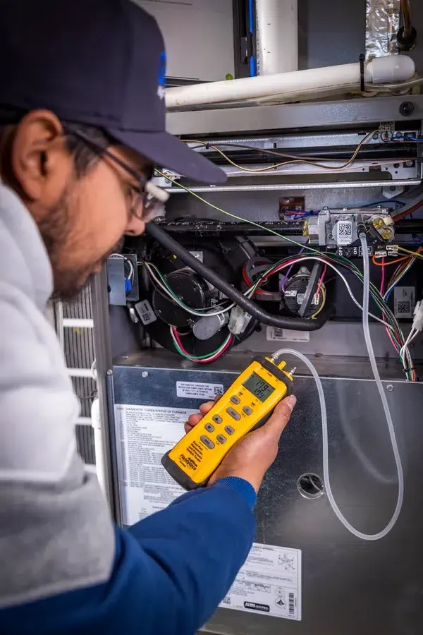 Goettl’s High Desert Mechanical technician testing electrical components inside furnace cabinet – Prescott Valley AZ