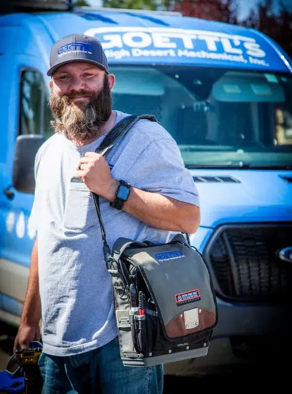 Goettl’s High Desert Mechanical technician standing by service van holding tool kit – Prescott Valley AZ
