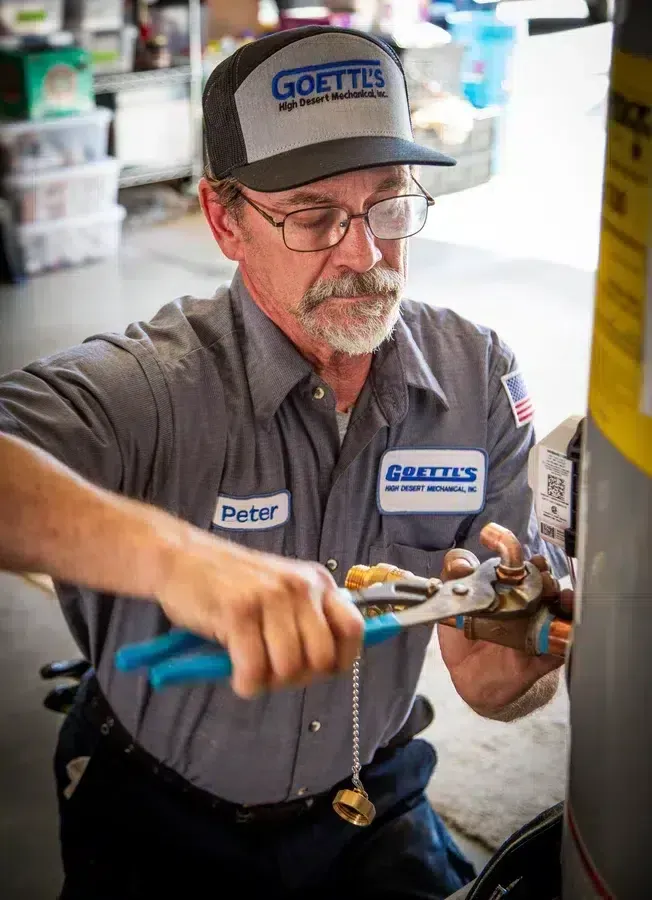 Goettl’s High Desert Mechanical technician adjusting fittings on water heater system – Prescott Valley AZ