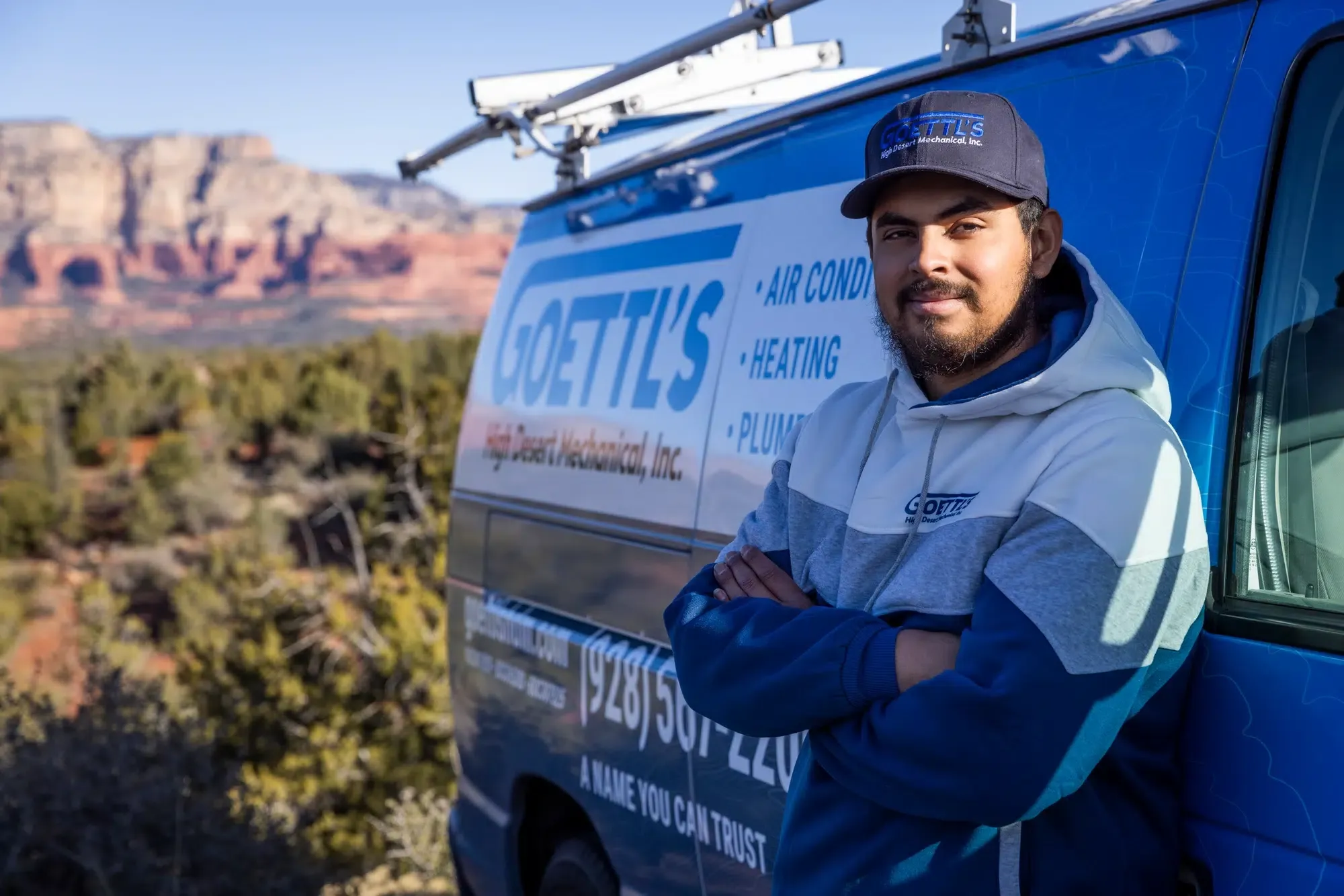 Goettl’s High Desert Mechanical technician standing beside service van with desert scenery – Prescott Valley AZ