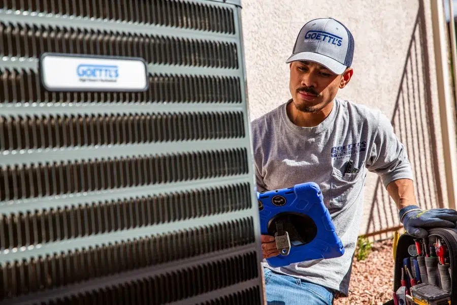 Goettl’s High Desert Mechanical technician completing air conditioning maintenance outside home in Prescott Valley AZ