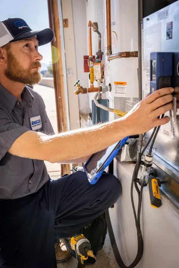 Goettl’s High Desert Mechanical technician working on wall-mounted HVAC system indoors – Prescott Valley AZ