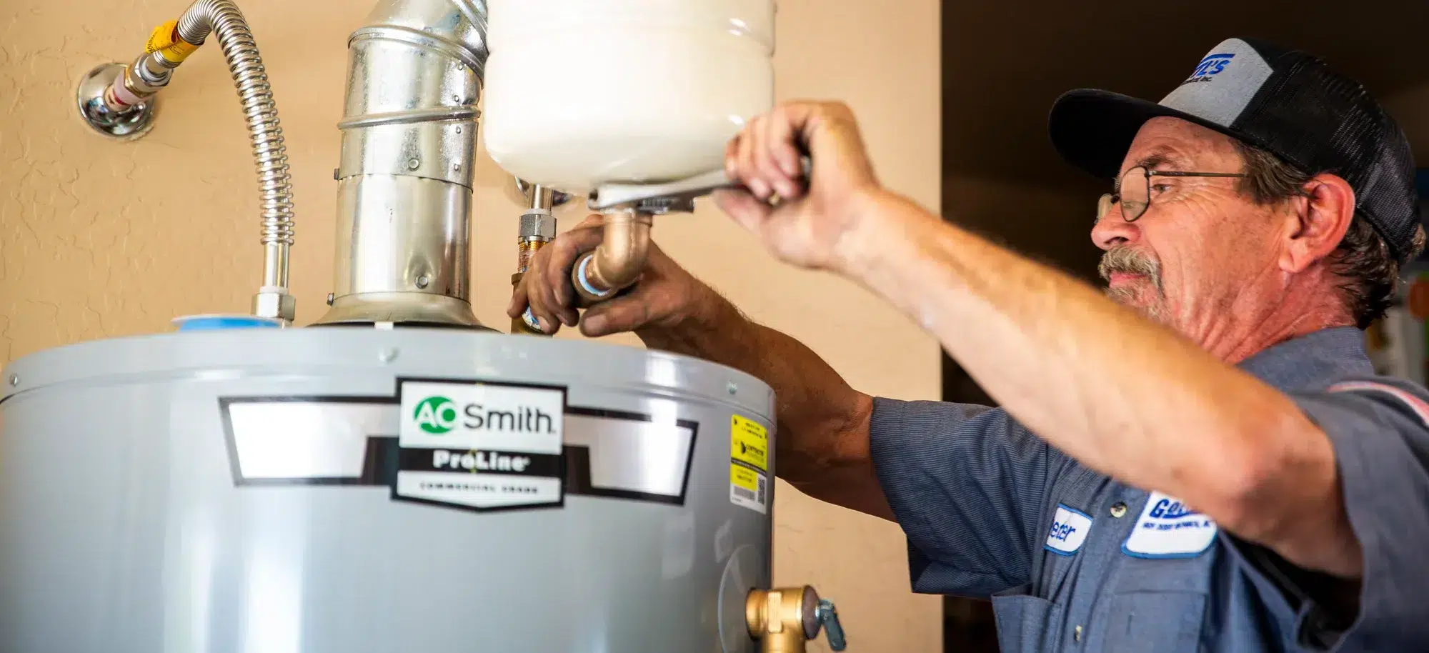 Goettl’s High Desert Mechanical technician tightening top fittings on water heater – Prescott Valley AZ