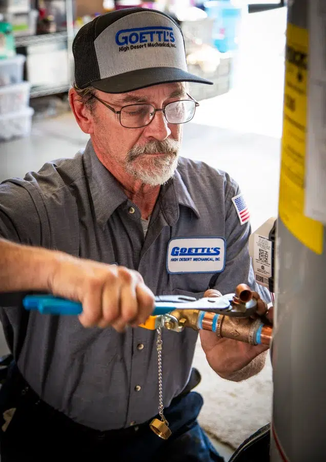 Goettl’s High Desert Mechanical technician adjusting copper piping on water heater system – Prescott Valley AZ